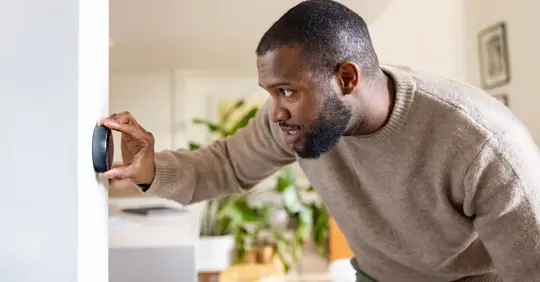 Man adjusting thermostat