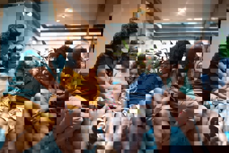 A happy, multi-generational family, including children and grandparents, laughs together