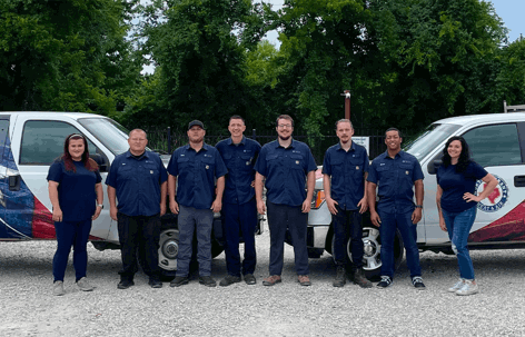 A team of eight employees, likely HVAC technicians and staff,
