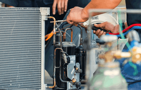 Technicians meticulously work on the internal components of an outdoor AC unit,