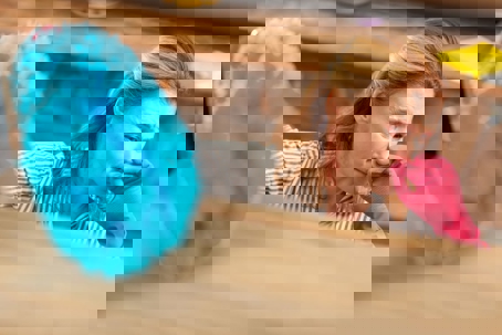 A woman in pink cleaning gloves holds her nose